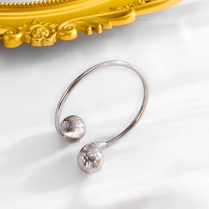 Macro shot of silver textured droplet bangles with intricate engraving on white marble