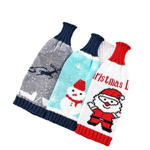 Three-piece knitted Christmas wine bottle covers featuring reindeer, snowman, and Santa motifs