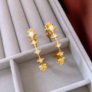 Detail of 18k gold plated tiger eye star earrings with pearls and small zircons