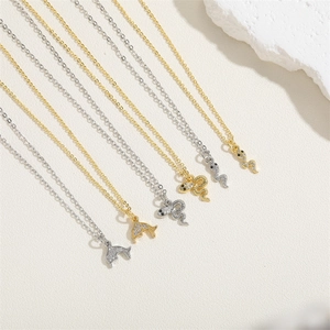 Detailed display of gold and silver snake pendants on fine 14K gold chains over white stones
