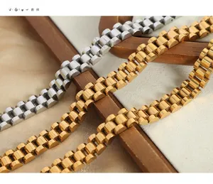 Macro shot of industrial gold and silver titanium steel link bracelets on linen fabric
