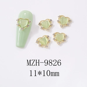 Macro view of 11x10mm heart cat eye nail charms with gold plating and white rhinestones