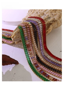 Detail view of colorful rectangular zircon bracelets with gold plating on rock display