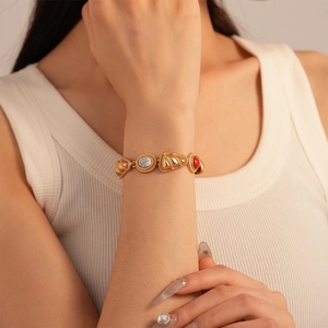 Detail of vintage gold bracelet with geometric marble inlays worn on a model's wrist