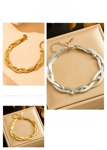 Detail of woven triple-strand snake chain bracelet in gold and silver with lobster clasp