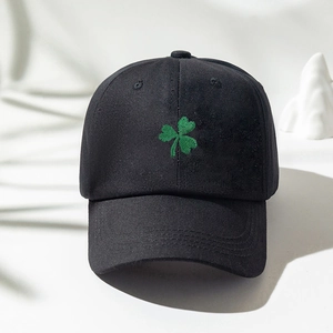 Classic black cotton baseball cap with green clover embroidery on a minimalist background
