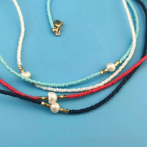 Detail of beaded necklaces with freshwater pearls and colorful seed beads in four colors