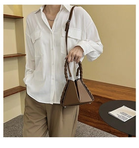 Brown geometric leather handbag with a braided handle and adjustable shoulder strap detail