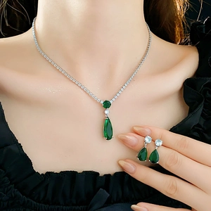 Detail of emerald teardrop zircon necklace and earrings set worn by a model