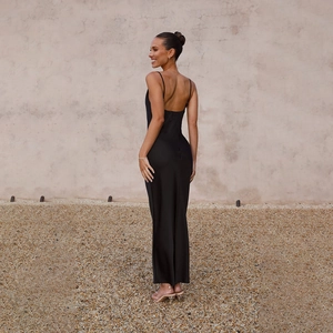 Detail shot of the backless design and smooth silk-like texture of the long black dress