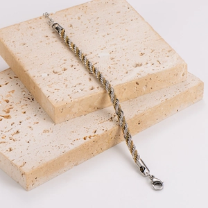 Macro detail of 5mm two-tone twisted rope chain with gold and silver link texture