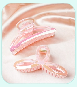 Detail of pink mermaid jelly hair clips on silk fabric with iridescent pearl finish