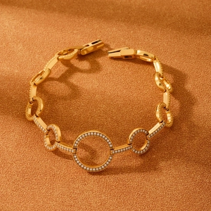 Golden heart and circle link bracelet with 5A zircons on a warm textured background