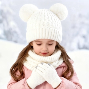 Detail of white knit hat with double pom-poms, matching scarf and gloves for winter