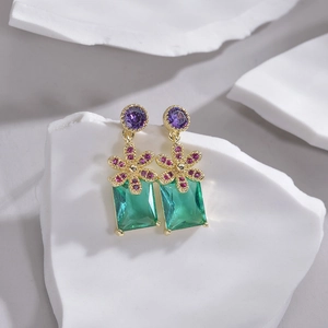 Floral earring with purple gems and rectangular emerald stone on white background