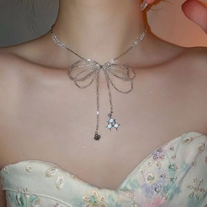 Detailed macro of crystal beaded necklace with bowknot and heart fringe pendants