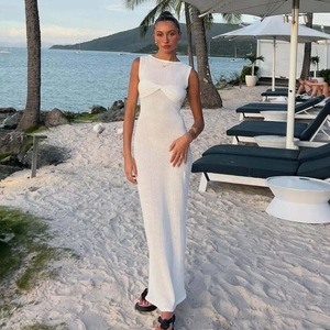 Detailed view of white sleeveless maxi dress featuring a twisted bust design on a beach