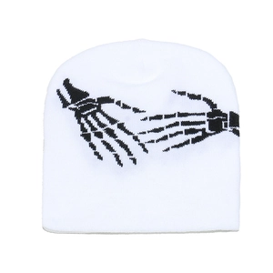 Détail du bonnet blanc en maille avec motif jacquard de main de squelette punk