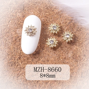 Macro view of 8x8mm gold star nail charms with crystal rhinestones on white nails