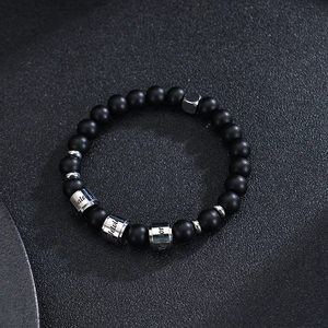 Detail of 8mm matte black stone beads bracelet with custom engraved stainless steel ring
