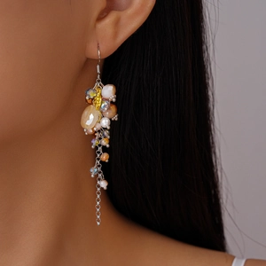 Macro side view of ethnic long glass bead tassel earrings worn by a female model
