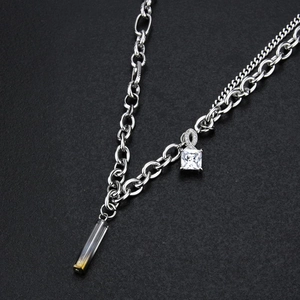 Détail du collier argenté avec pendentif en zircon carré et accents en or 18 carats