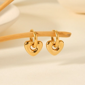 Eleganti orecchini a cuore in acciaio inossidabile placcato oro 18K su un ramo rustico