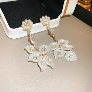 Detail showing shell flower earrings with dangling leaves, pearls and zircon crystals