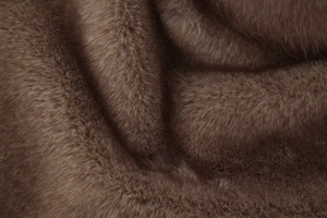 Gros plan sur la texture de fourrure synthétique marron montrant les poils doux et denses