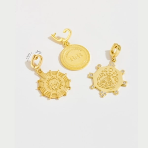 Detailed view of sun, moth, and 11:11 engraved gold charms with cubic zirconia