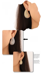 Detail of tear-drop earrings with full rhinestone inlay in gold and silver plating