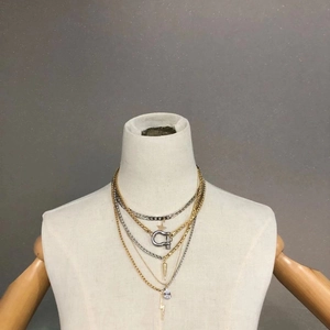 Layered gold and silver punk chain necklace with star and lightning charms on a mannequin