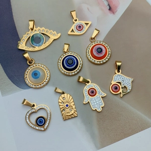 Macro shot of assorted gold-plated stainless steel charms with evil eye and heart motifs
