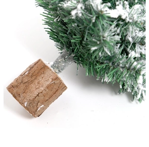Close-up of mini Christmas tree with flocked snow and natural wooden base detail