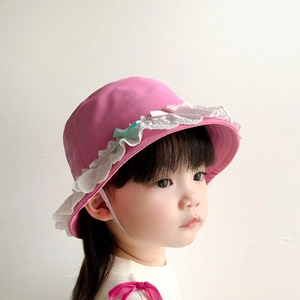 Detailed side view of pink kids bucket hat with delicate lace trim and bows