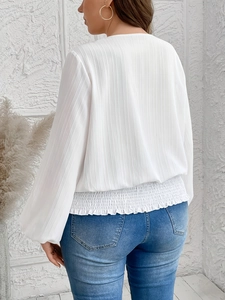 Elegant white long sleeve pleated top with elastic hem shown from a back view