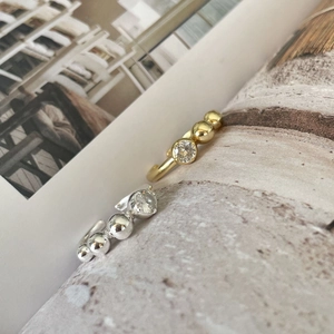 Detailed macro view of gold and silver beaded rings with round cubic zirconia settings