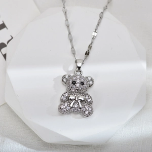 Sparkling silver bear pendant necklace with zircons on a white geometric stone