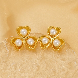Elegant gold clover stud earrings with white pearls on a luxurious silk background