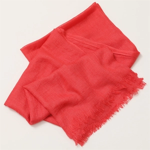 Detail of red linen scarf with soft fringe trim, lightweight breathable fabric texture