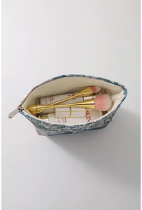 Top view of blue floral jacquard cosmetic bag with silver zipper and spacious interior