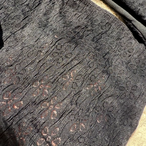 Close-up of black bikini fabric featuring three-dimensional floral textures and lace details