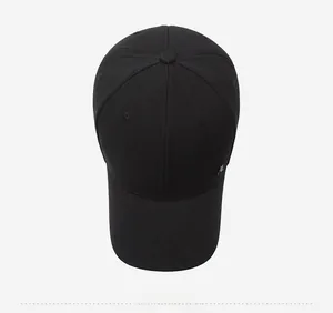 Vue de dessus détaillée d'une casquette noire avec logo métallique argenté et coutures