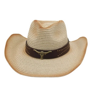 Detail of western straw hat with vintage bull head metal ornament on leather band