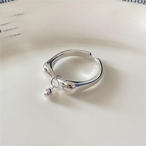 S925 sterling silver water drop ring with bell charm on white ceramic plate