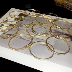 Detailed view of 18k gold plated bracelets featuring snake head and clover designs