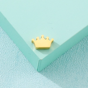 Minimalist gold crown pendant accessory made of stainless steel on mint green base