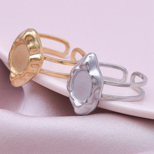 Detail of adjustable lava-style gold and silver rings with oval top on pink silk