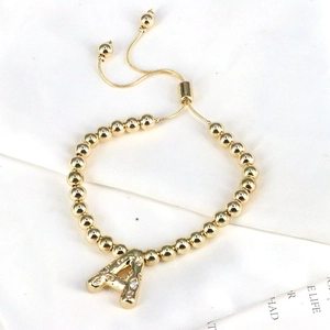 Adjustable gold beaded bracelet featuring a crystal-encrusted letter A pendant