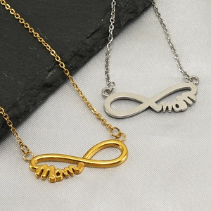 Gold and silver infinity MOM necklaces on textured stone and fabric background
